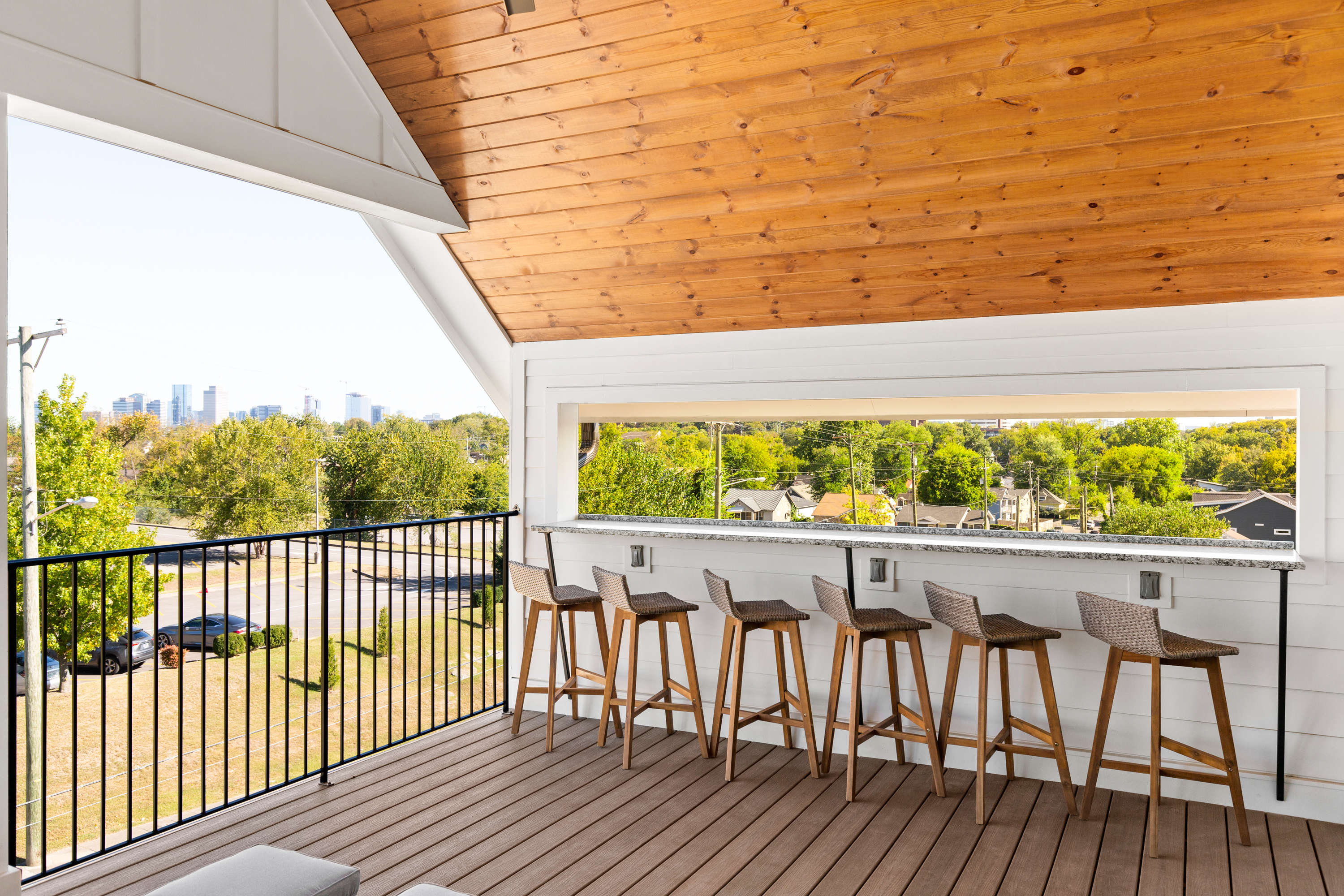 Stylish rooftop deck with bar stools overlooking the city skyline